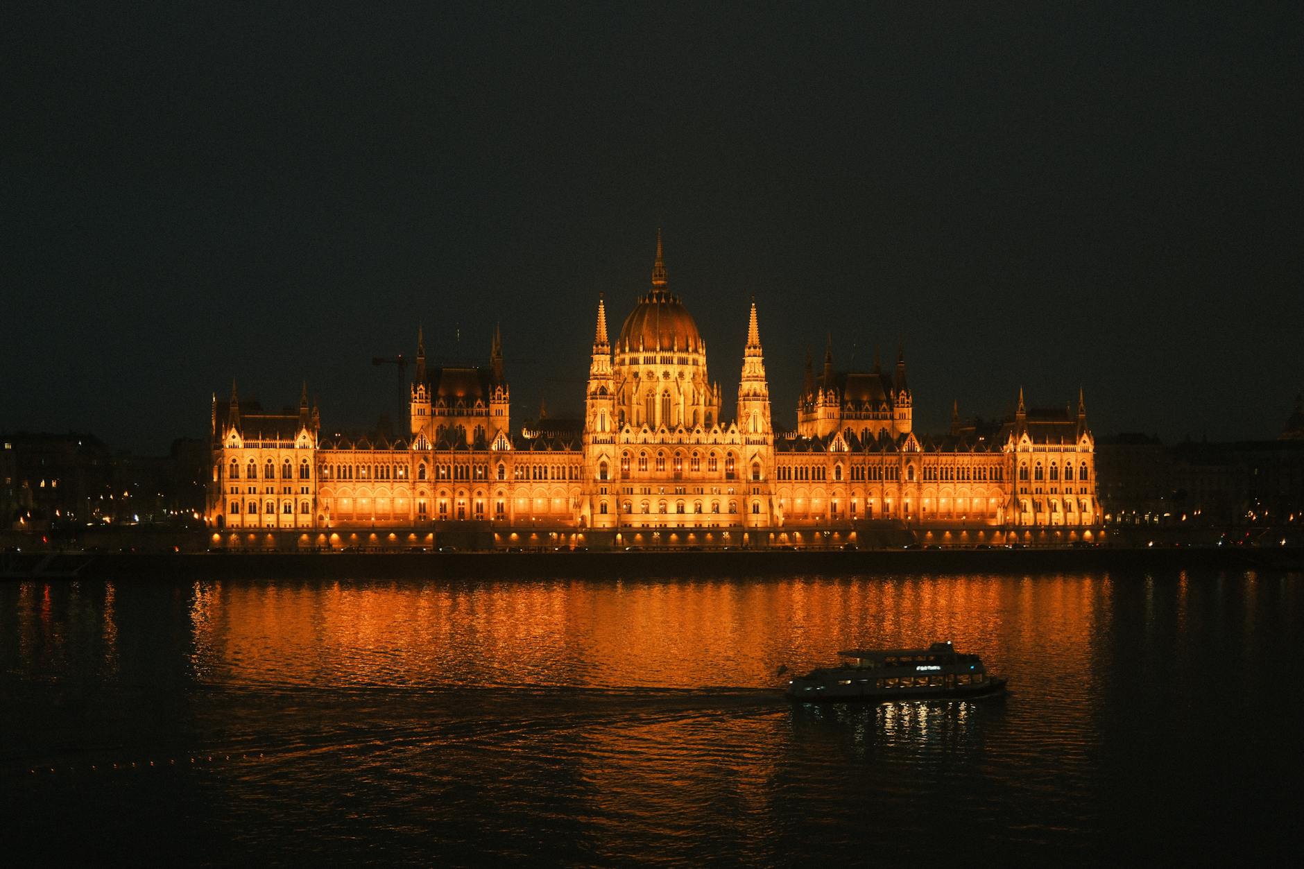 Budapest Parliament Building illuminated at night reflecting on the Danube River