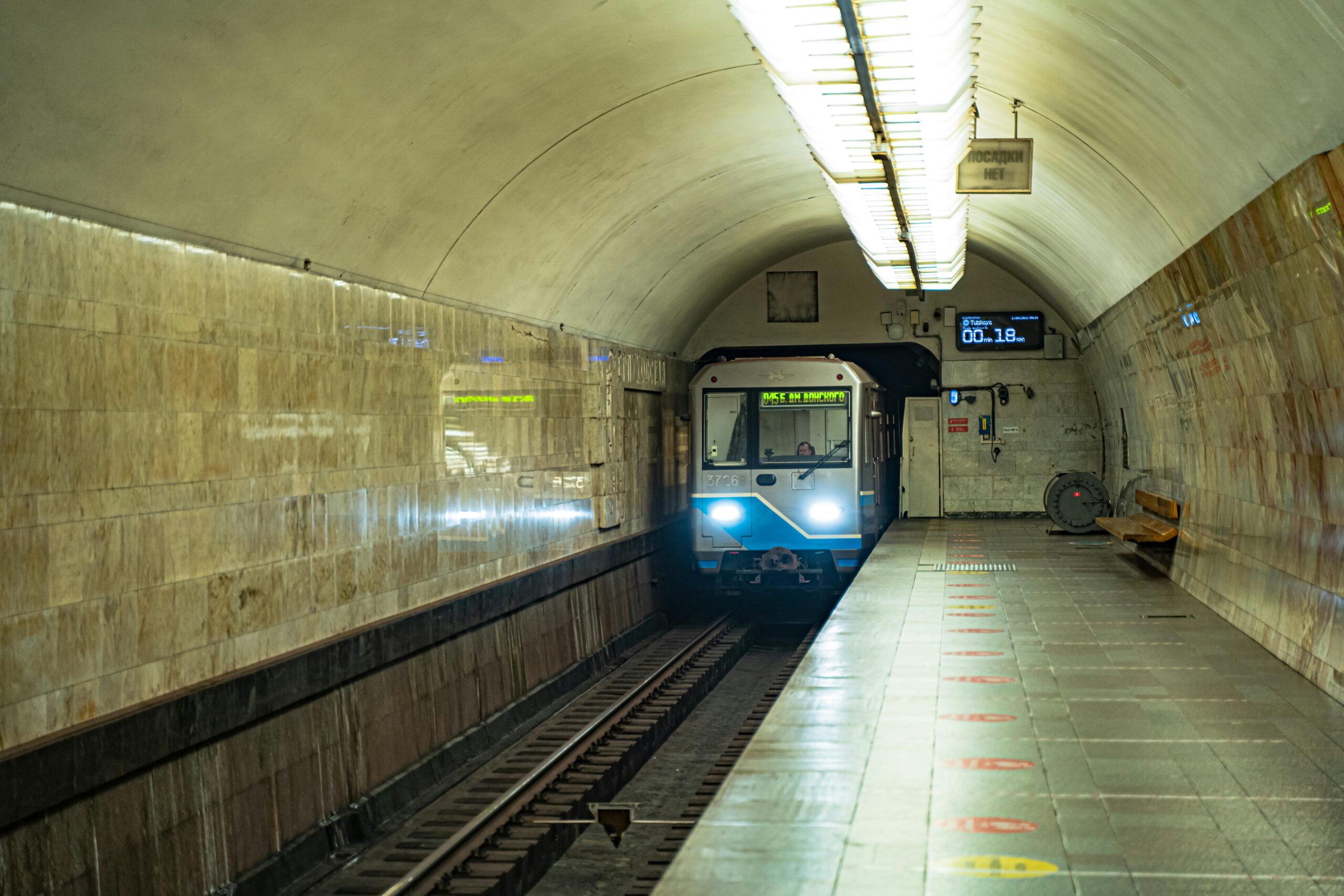 A small yellow Budapest M1 metro train at a shallow tiled platform on the Millennium Underground line