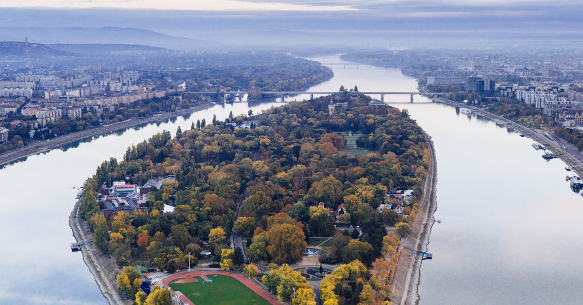Luxurious hotel room with a large bed, elegant furnishings, and a window view of Budapest's historic architecture