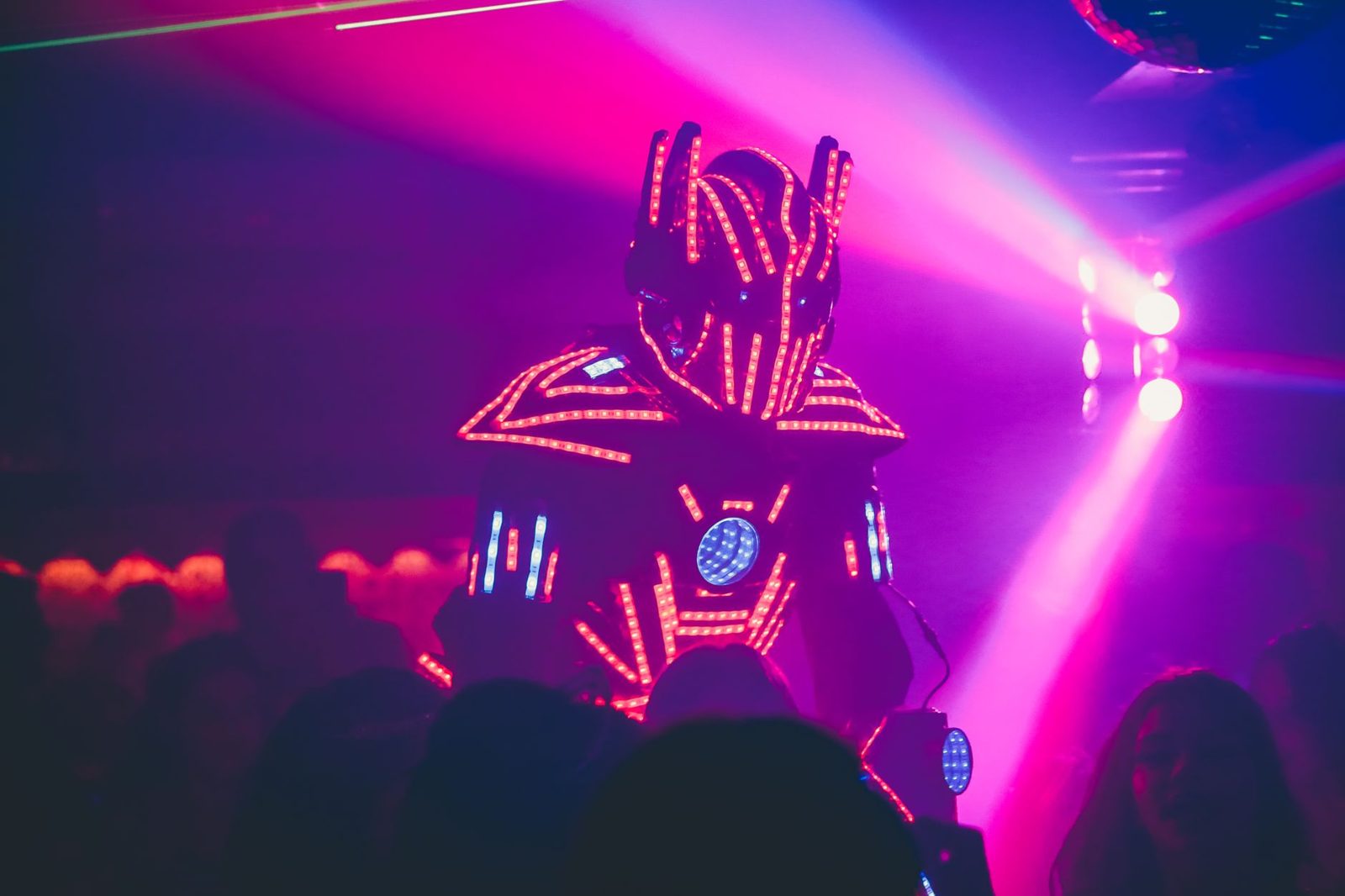 A neon-lit nightclub party crowd