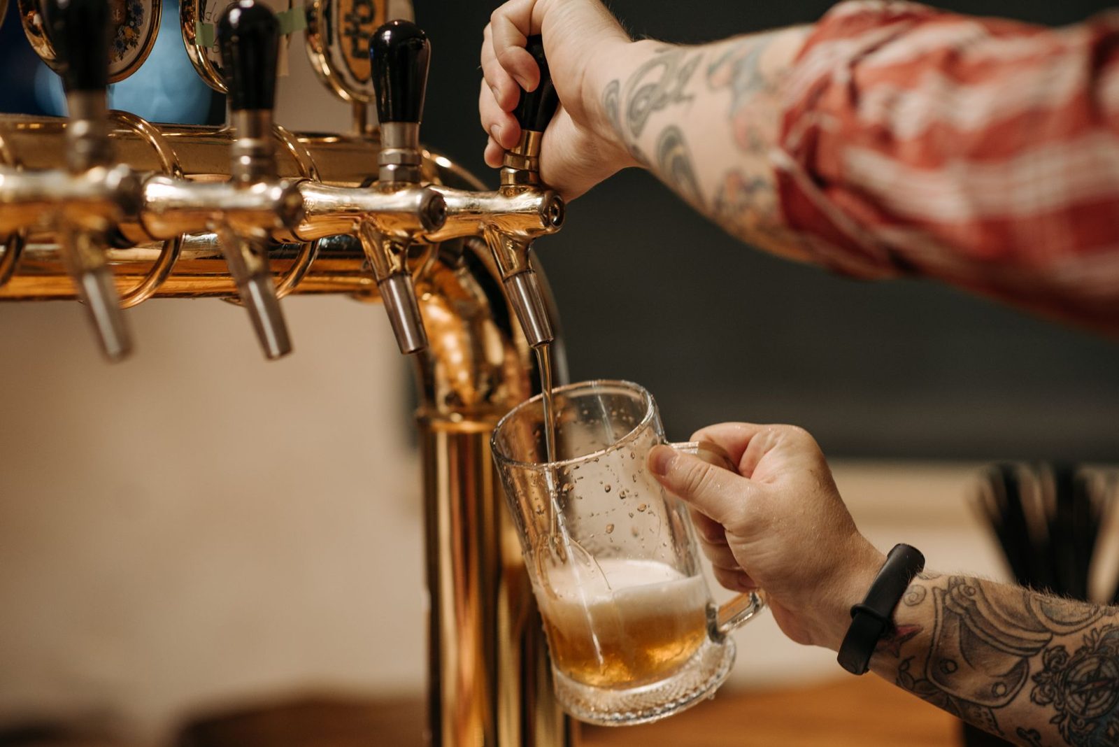 Craft beer being poured from rotating taps at a Budapest bar