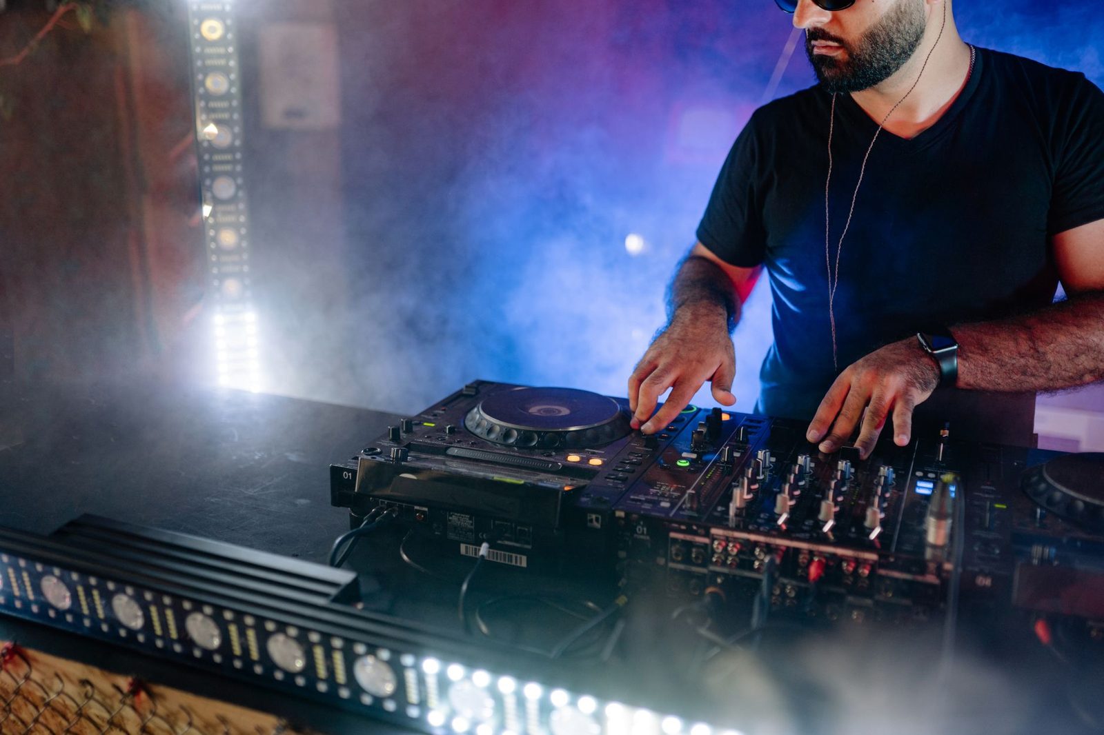 A DJ playing to a crowd under club lights