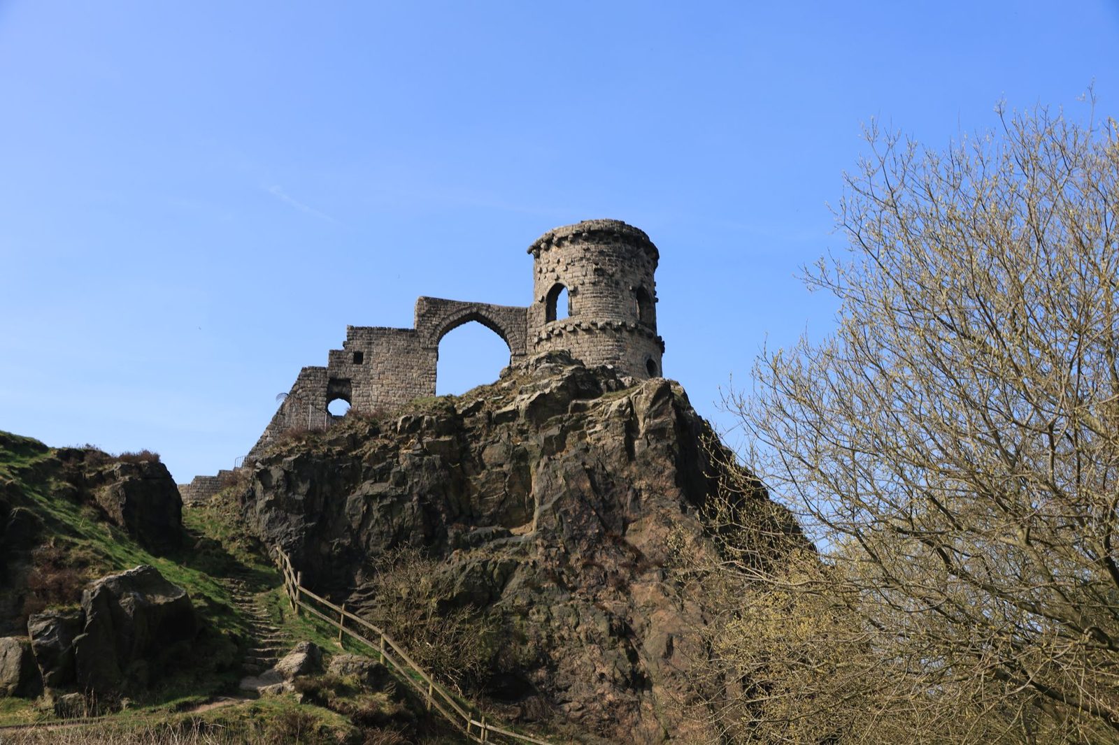 Medieval castle ruins on a wooded hill above the village