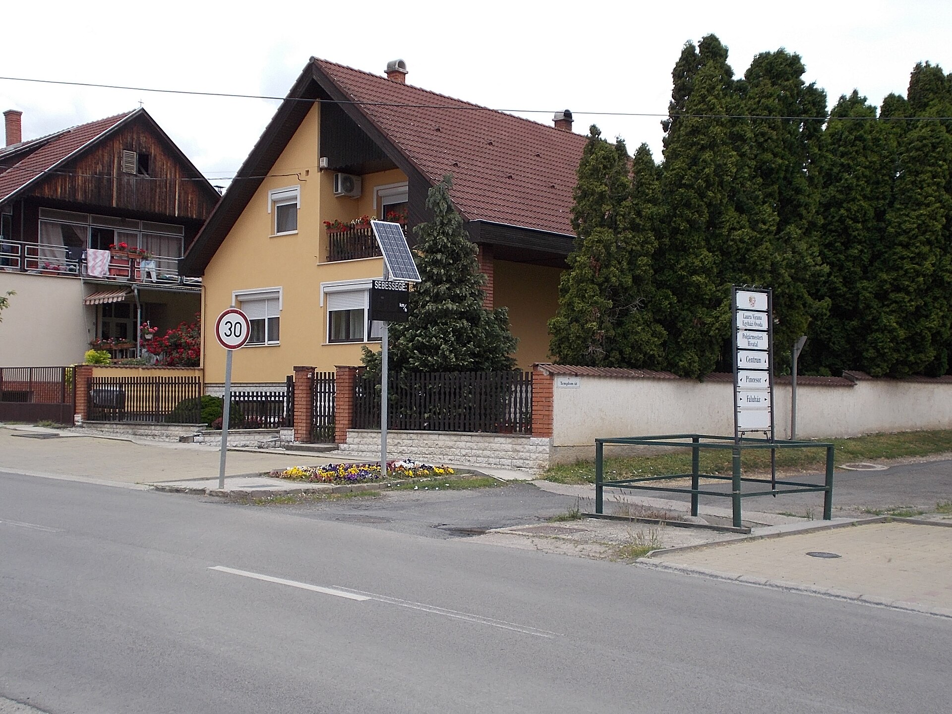 A 30 km/h speed limit sign with a solar-powered radar unit on a village street in Hungary