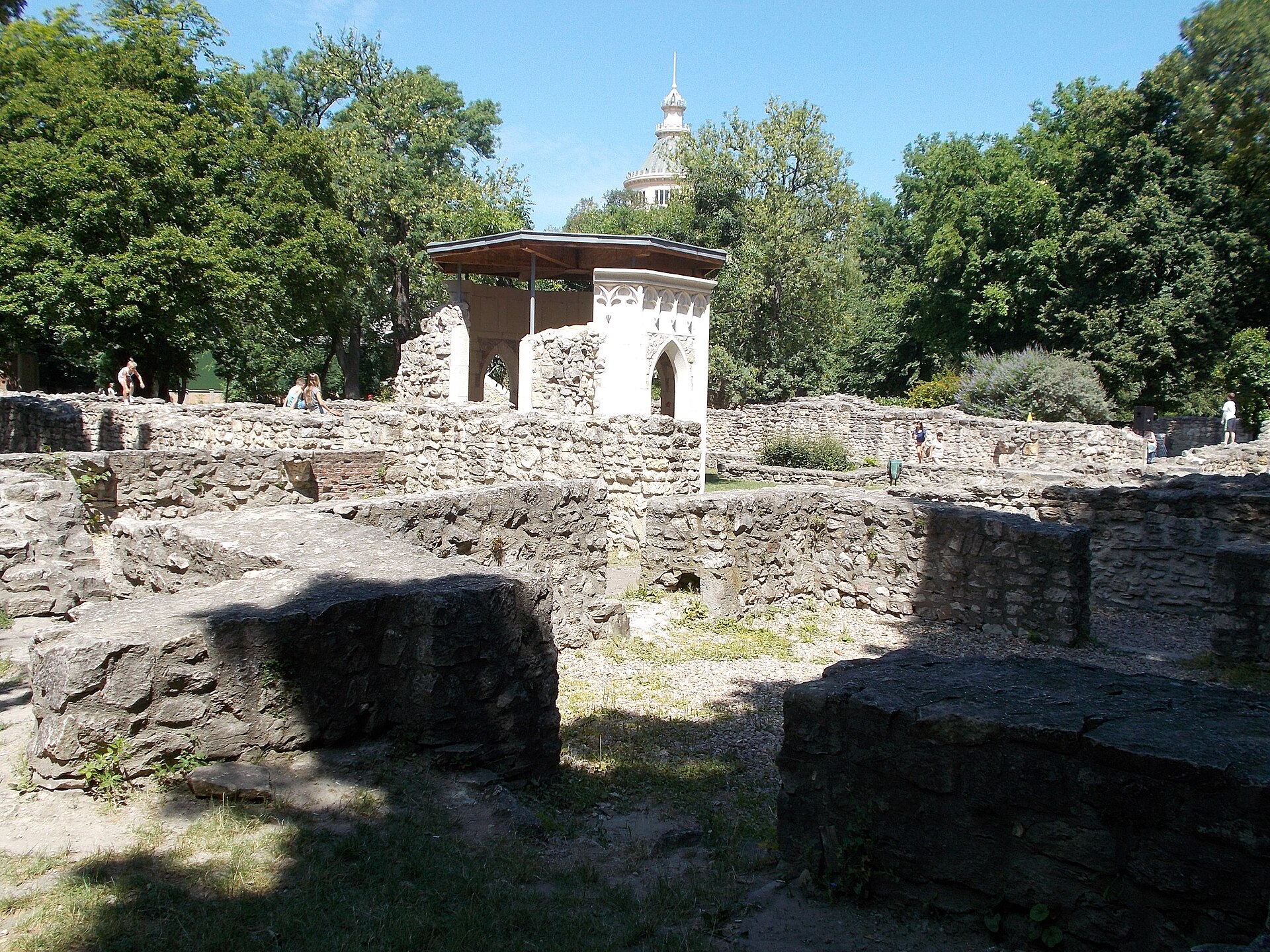 The stone ruins of the medieval Dominican convent on Margaret Island with a reconstructed Gothic well house and the water tower behind