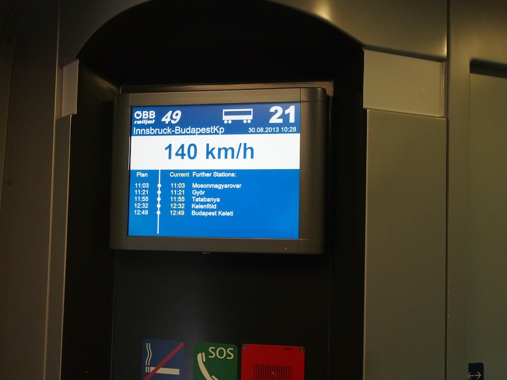 A Railjet onboard screen showing the train's speed and its next stops: Mosonmagyaróvár, Győr, Tatabánya, Kelenföld and Budapest Keleti