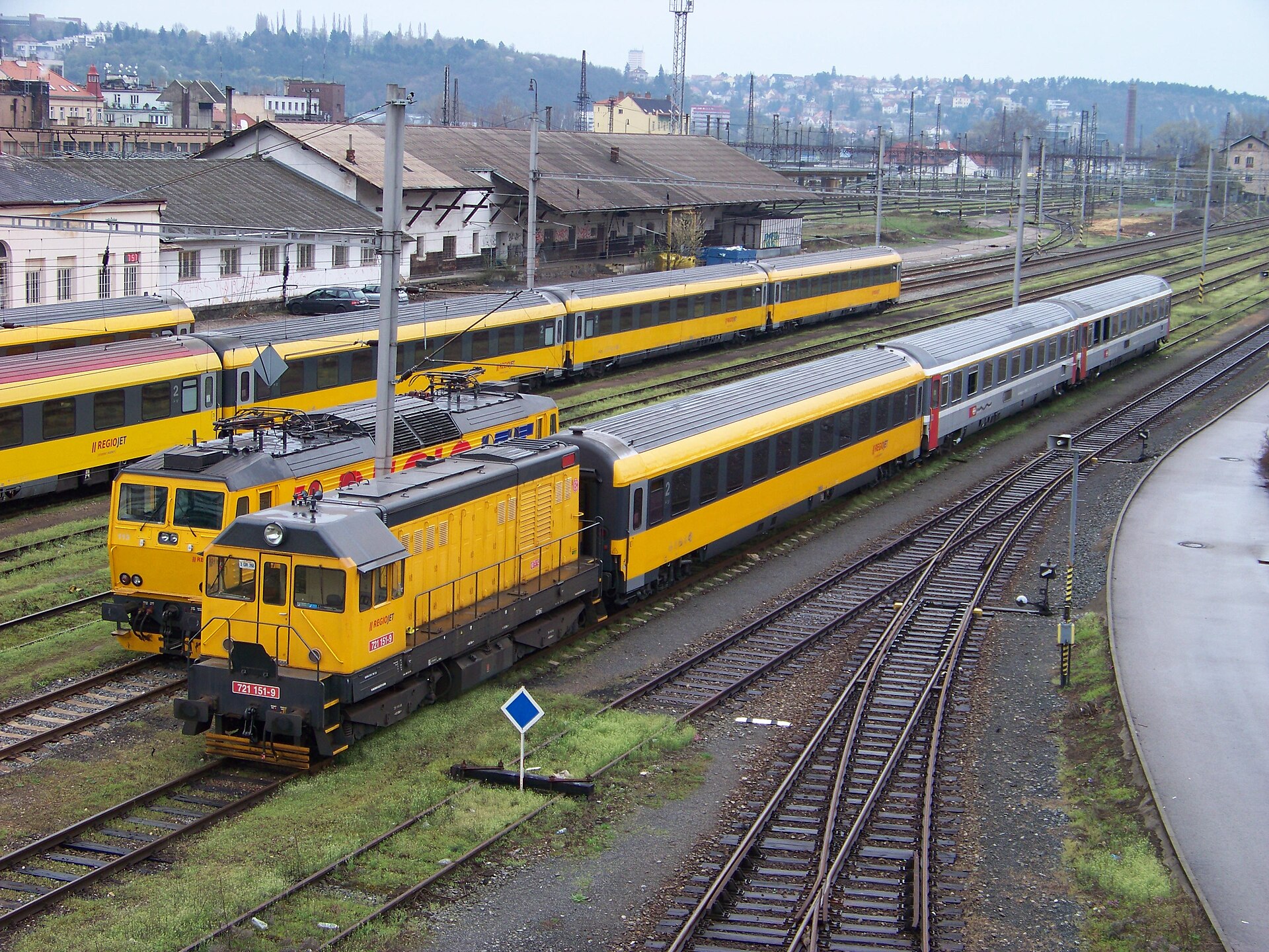 Yellow RegioJet trains at a railway station in Czechia