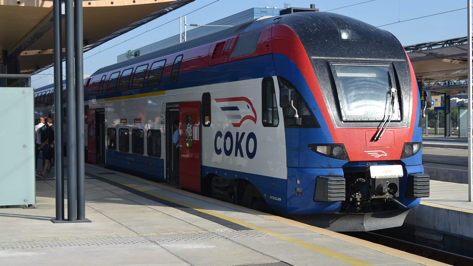 A red, white and blue SOKO double-deck high-speed train of Serbian Railways at a modern station platform