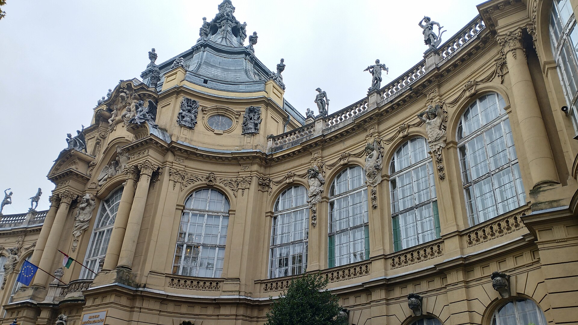 The ornate baroque wing of Vajdahunyad Castle in Budapest's City Park, with statues along the roofline and tall arched windows